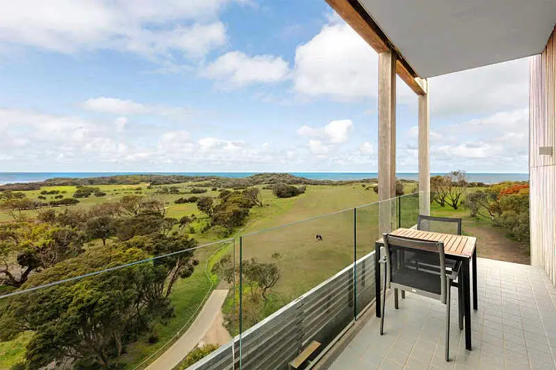 Balcony and outdoor furniture with views of the surrounding landscape at the RACV Torquay Resort accommodation in Torquay Victoria.