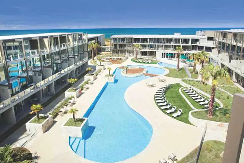 Aerial view of the pool and surrounding buildings with the ocean in the background at Wyndham Resort Torquay accommodation.