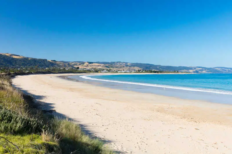 The white sands and blue waters of Apollo Bay Beach on the Great Ocean Road in Australia.