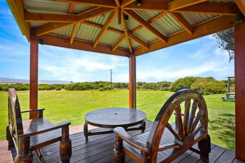 Deck with table and chairs and country views at Apollo Bay Cottages.