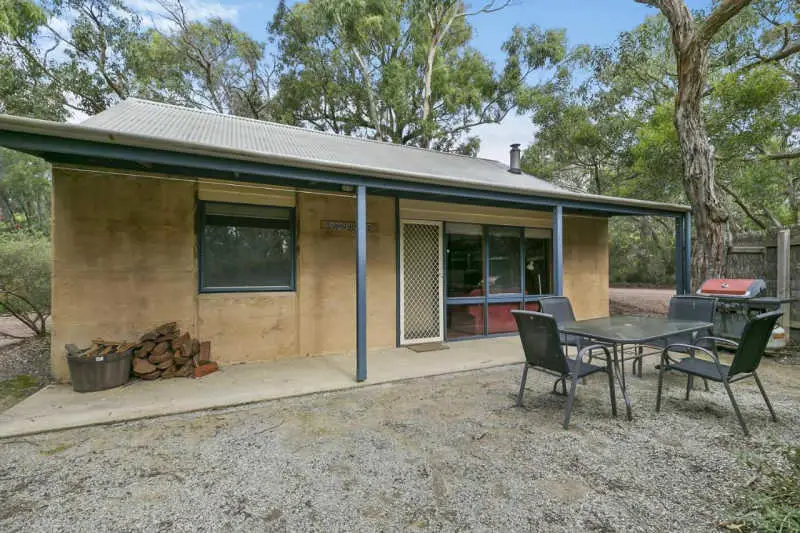 Image of a cottage at Split Point Cottages accommodation in Aireys Inlet with a verandah and outdoor barbecue area.