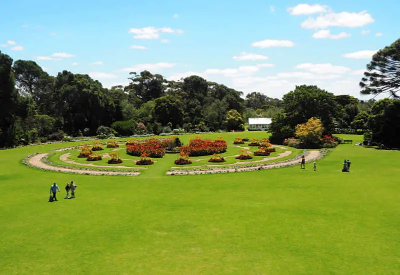 People walking on the lush green lawns at the Werribee Park Mansion Gardens.