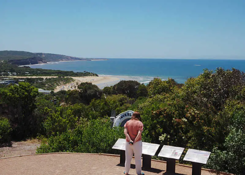 Woman reading the information boards at Loveridge Lookout with views of the beach and ocean at Anglesea in Victoria.