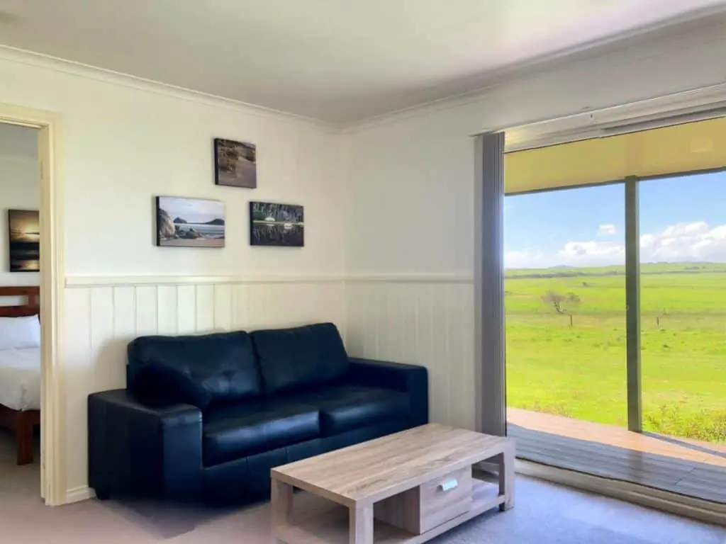Lounge and large window with views at Promhills Cabins Wilsons Promontory accommodation.