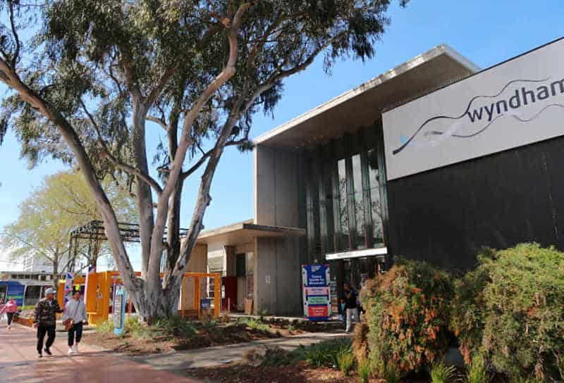 Beautiful tree with people walking past the entrance to the Wyndham Cultural Centre and Wyndham Art Gallery.