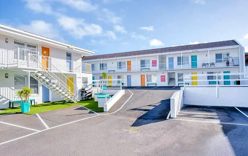 Image of the Comfort Inn Warrnambool International motel a white building with bright colourful doors.
