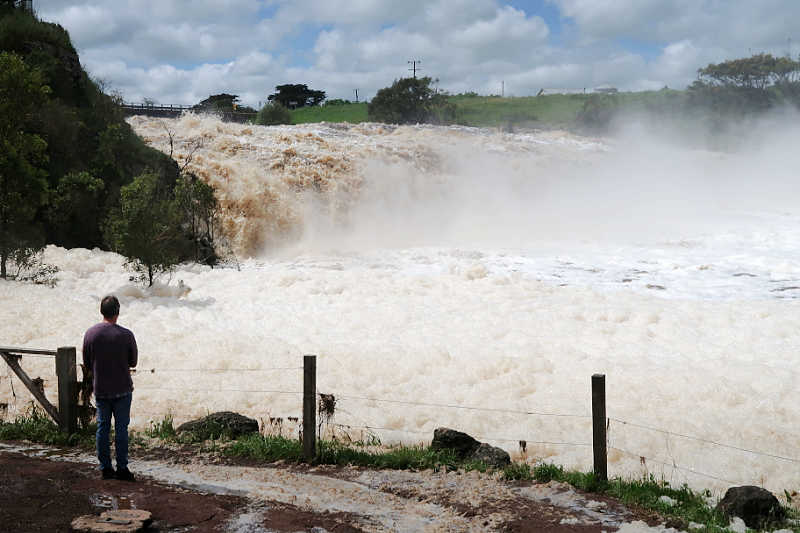 Tourist watching the water cascade over Hopkins Falls in Victoria Australia.