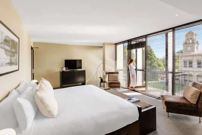 Lancemore Werribee Hotel room with guest enjoying the view from the floor to ceiling window.