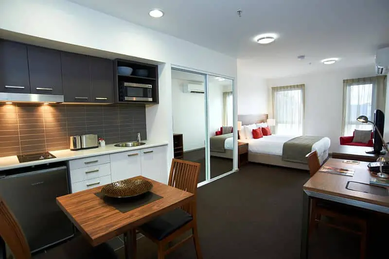 Guest room at Quest Werribee with a kitchenette, bed, and table.