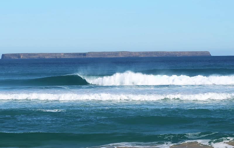 Waves crashing into shore with Lady Julia Percy Island in the background.