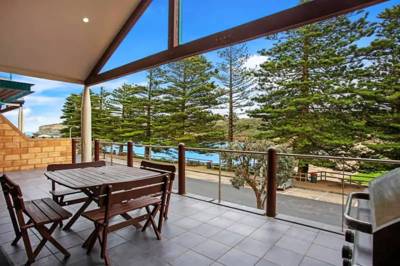 Balcony with views of the beach and trees at Sea Foam Villas accommodation in Port Campbell.