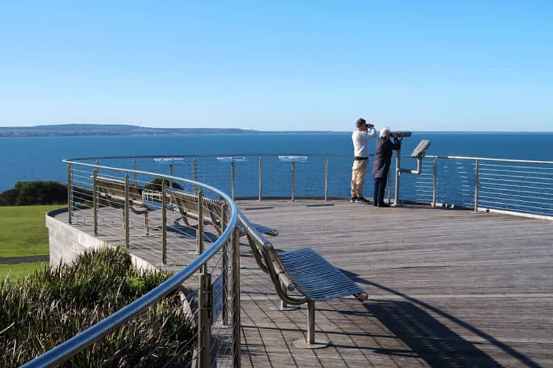 People looking out to sea at the Portland Whale Watching Platform in Victoria.