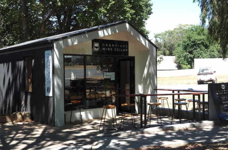 Grampians Wine Cellar with outdoor stool and bench seating under a shady tree.