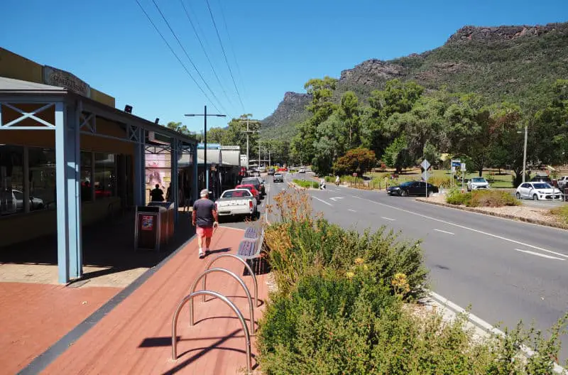 Things to do in Halls Gap. Man taking a stroll around the town centre under a bright blue sky.