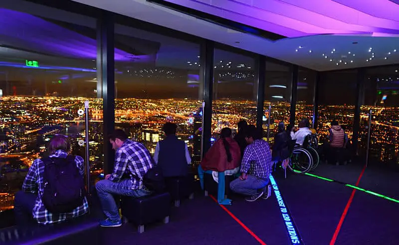 People viewing the city lights at night from Melbourne Skydeck one of the fun things to do in Melbourne at night.