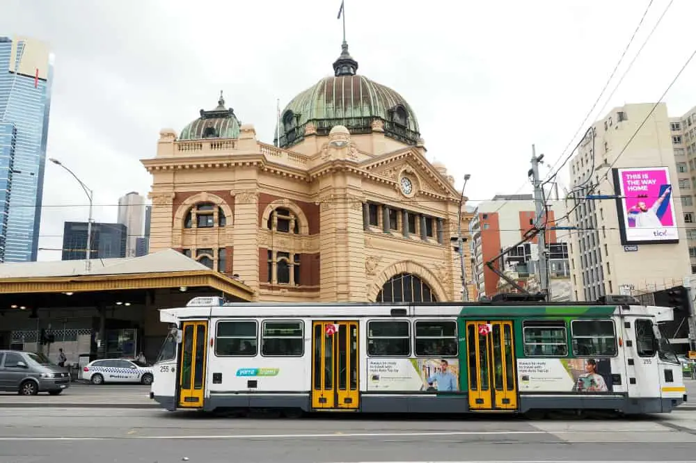 A Melbourne tram travelling past Flinders Street Station two of the most famous landmarks in Melbourne.