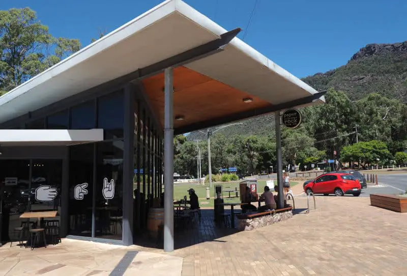 Relaxing outdoor area at Paper Scissors Rock Brew Co in Halls Gap with bright blue skies and the Grampians mountains in the background.