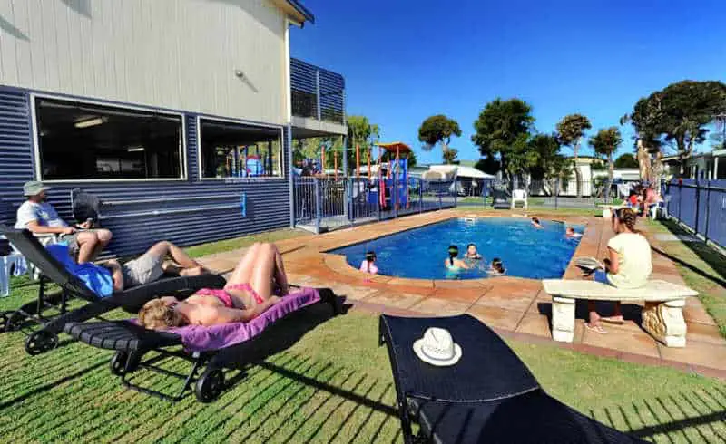 People relaxing around the swimming pool at Apollo Bay Caravan Park
