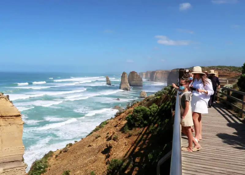 Tourists admiring the 12 Apostles on one of the best Great Ocean Road tours from Melbourne.