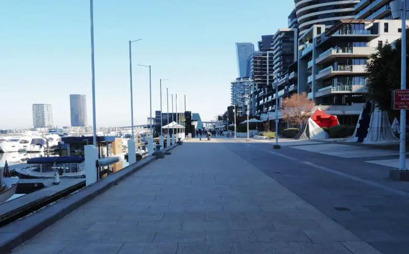 Image of Docklands promenade walk with buildings and blue sky.