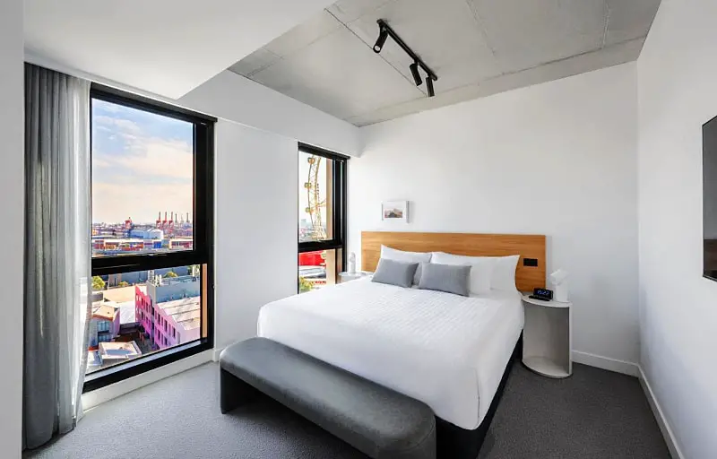 Guest bedroom with floor to ceiling windows at Nesuto Docklands.