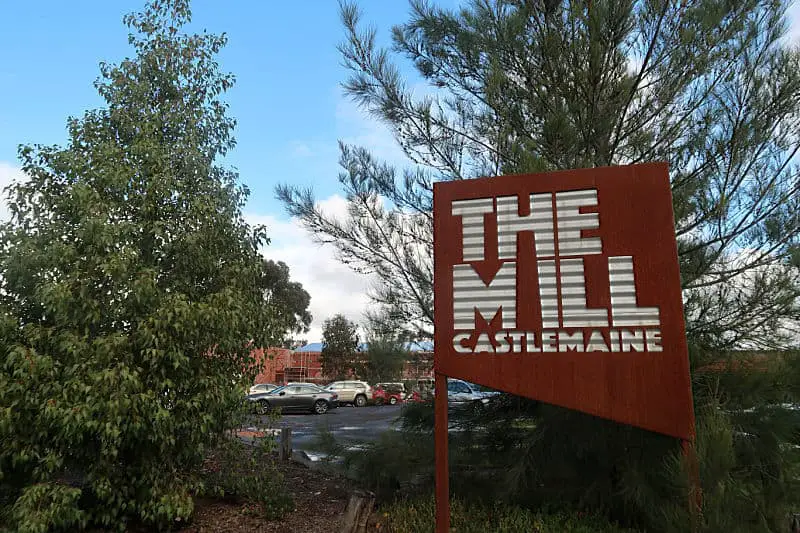 The Mill Castlemaine sign surrounded by trees and with blue skies.