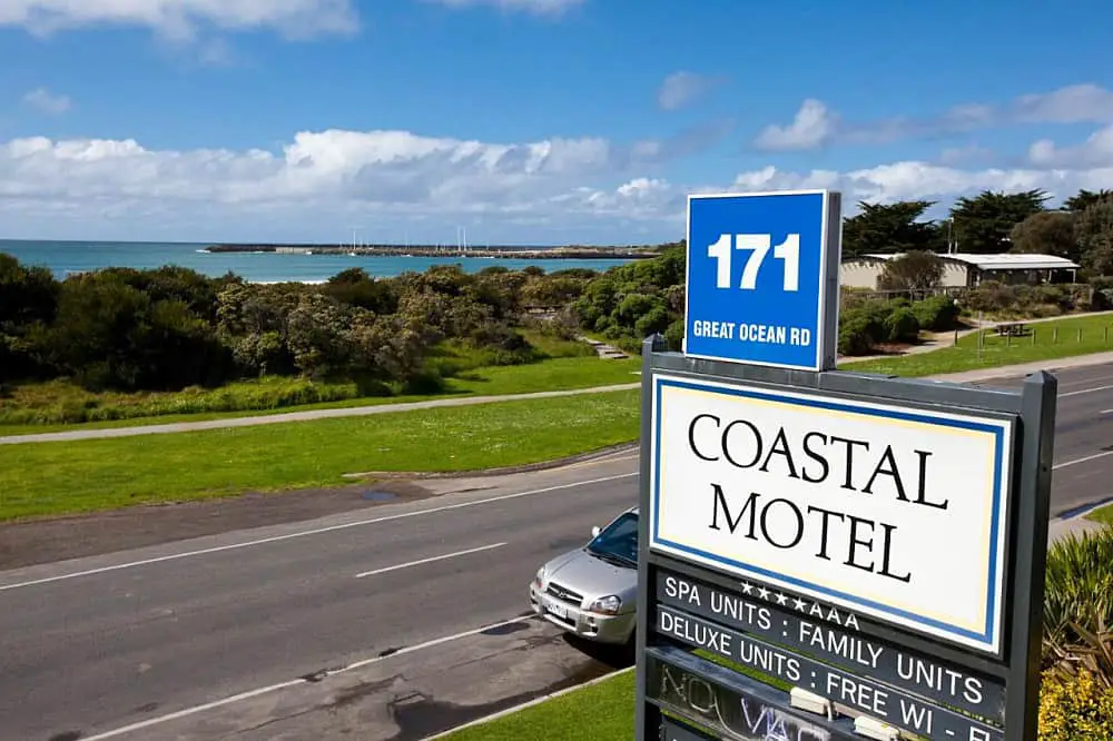 Coastal Motel sign with the ocean in the background.