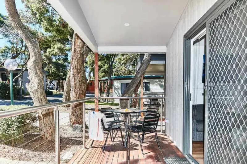 View of the outdoor verandah with table and chairs and gum trees at the Anglesea Family Caravan Park. A great choice for family accommodation in Anglesea. 