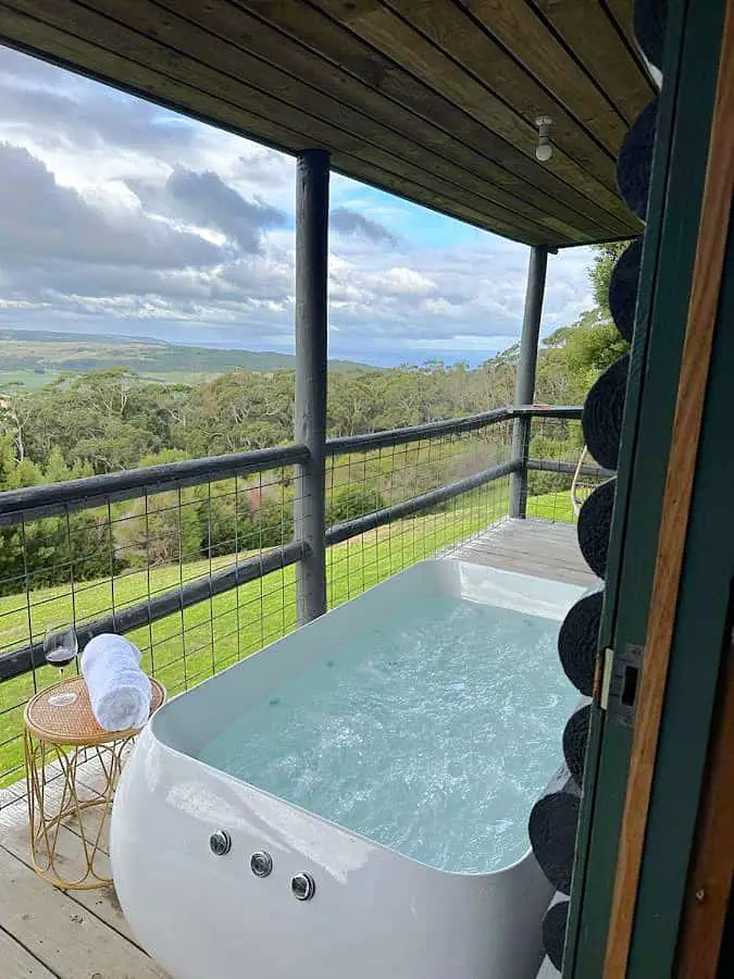 Balcony with outdoor spa bath overlooking beautiful forest views at Glenaire Cottages in the Otways.