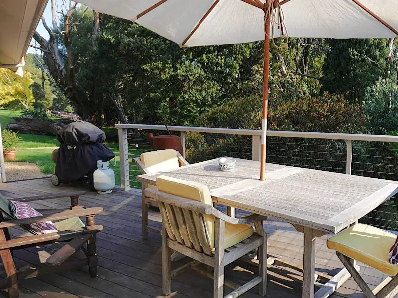 Picnic table and umbrella surrounded by greenery at The Otway Haven cottage accommodation.