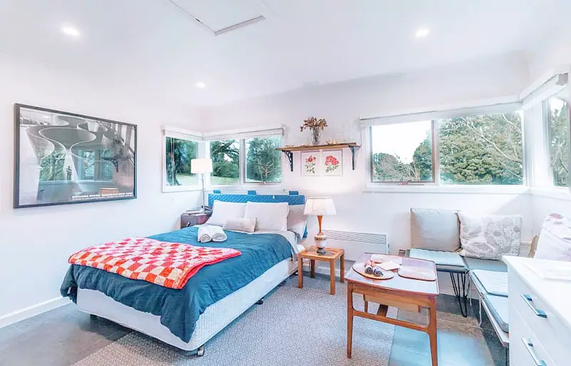 Studio room at The Otway Nest cottage with a double bed, couch, and a coffee table. 
