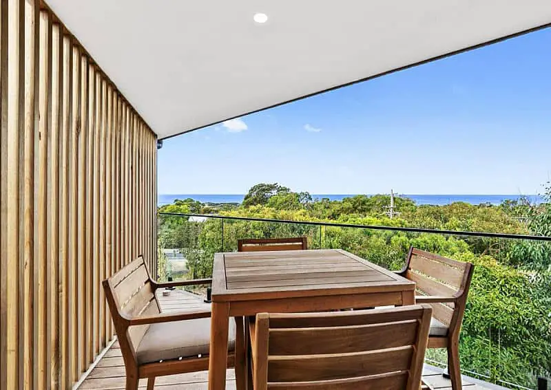 Balcony with a table and chairs and stunning ocean views at Point Break accommodation in Anglesea.