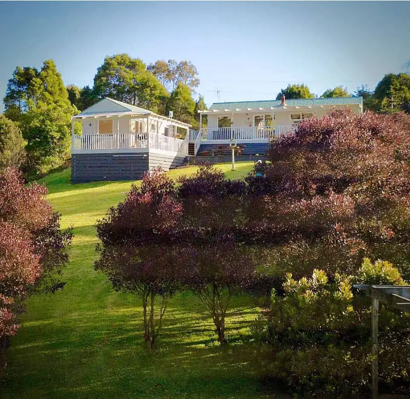 Redwoods Rest cottages in the Otways with verandahs surrounded by lush lawn and trees.