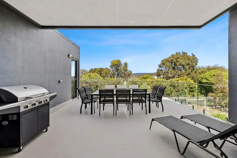 Balcony with outdoor furniture and barbecue at Aireys Sunset Beach House.
