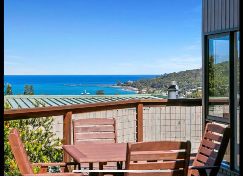 Balcony with table and chairs overlooking the ocean at Bay Views holiday house at Lorne Victoria. 