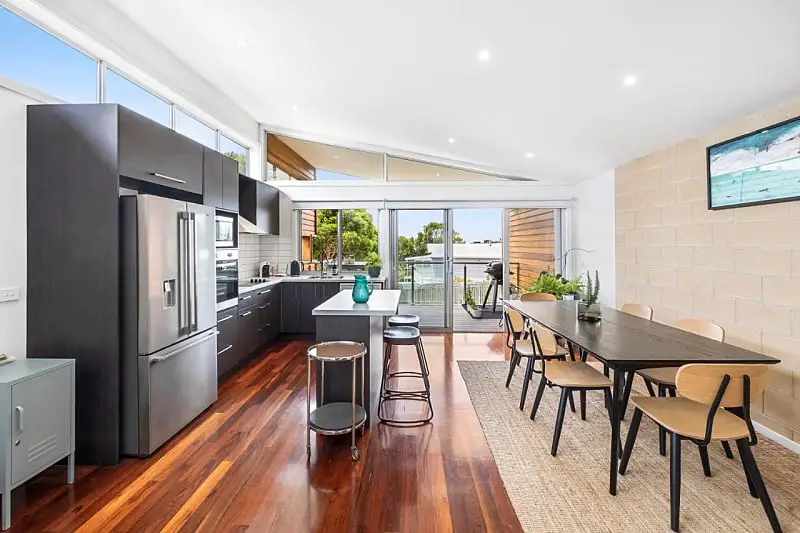 The modern kitchen and dining area with wooden floors at Beach Baby holiday apartment in Aireys Inlet Victoria.