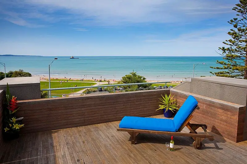 Outdoor decking with lounge chair overlooking the beach at Cumberland Resort accommodation Lorne.