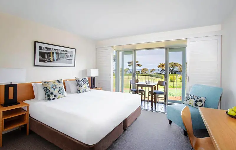 Guest room at Mantra Lorne hotel with a balcony and outdoor furniture.