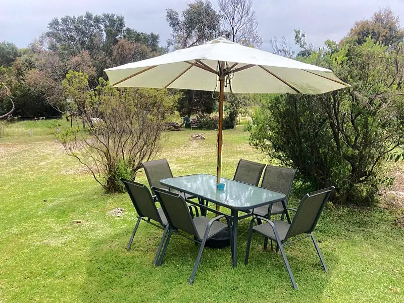 Picnic table and chairs with umbrella in the garden at Nunyara holiday accommodation Aireys Inlet.