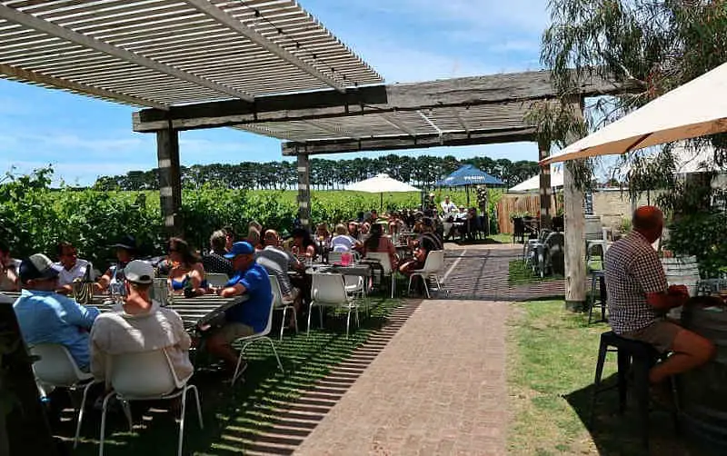People sitting undercover at outside tables at the Oneday Estate Bellarine Peninsula winery on a sunny day. 