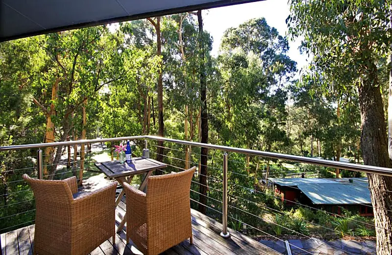 Balcony overlooking the bush with outdoor table and chairs at QDOS Tree House accommodation in Lorne.
