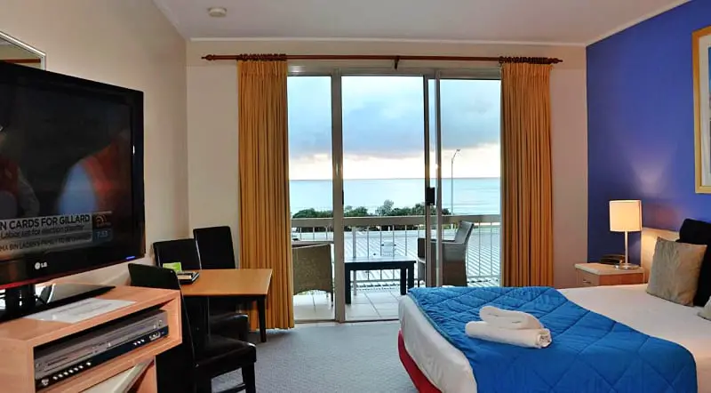 Guest room with balcony, outdoor furniture, and ocean views at Sandridge motel Lorne.