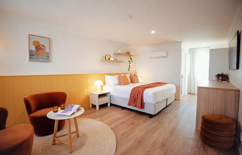 Guest room at Sunnymeade Hotel Aireys Inlet with a comfortable bed, sitting area and modern decor.
