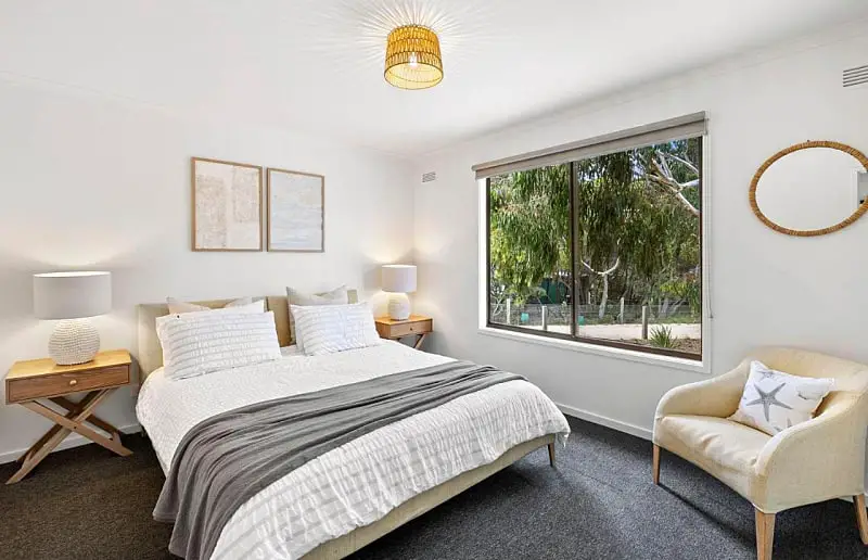 Guest room with a bed and chair and garden views at The Bungalow Aireys Inlet accommodation.