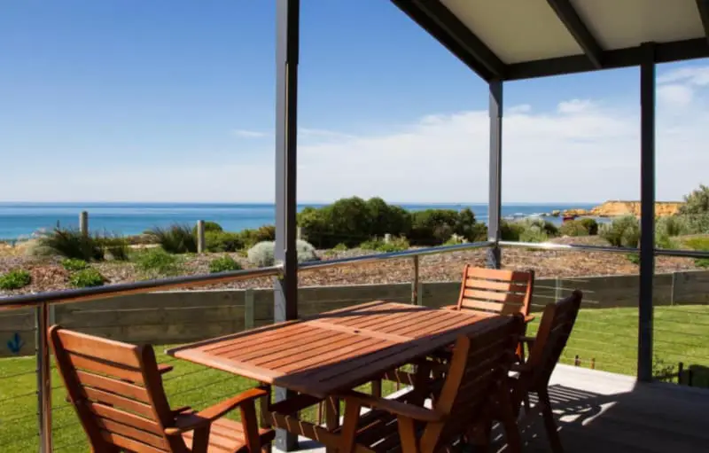 Cabin verandah with outdoor setting overlooking the surrounding landscape with views of the ocean at Torquay Foreshore Caravan Park.