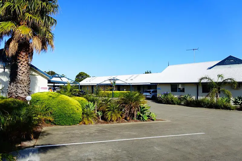 Entrance to the Tropicana Motel accommodation in Torquay. With a view of the driveway, garden and motel building.