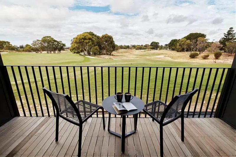 Balcony with outdoor furniture and coffee mugs on the table overlooking the fairway at Accommodation@Curlewis a highly-rated Bellarine Peninsula accommodation option.