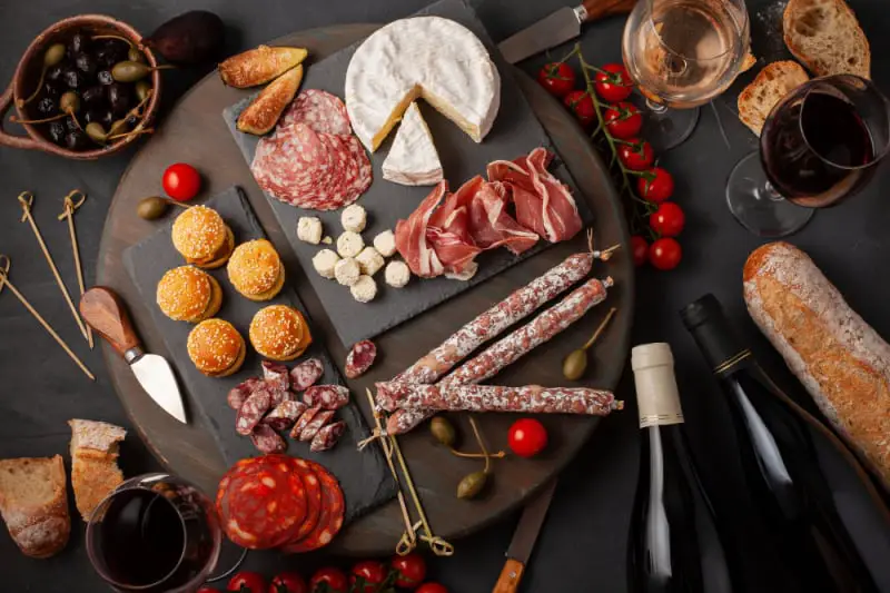 Charcuteries board with salami, cheeses, and bottles of wine. A Bellarine Winery tour with charcuterie board is a great way to see the Bellarine wineries in Victoria.