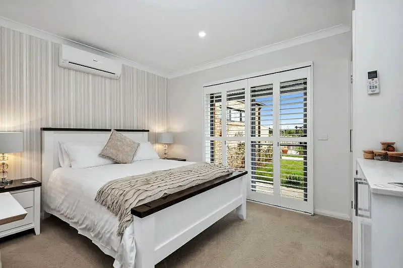 Guest room with double bed and large window with open shutters with views into the garden at Oxley Estate Bed & Breakfast in Portarlington on the Bellarine Peninsula Victoria.