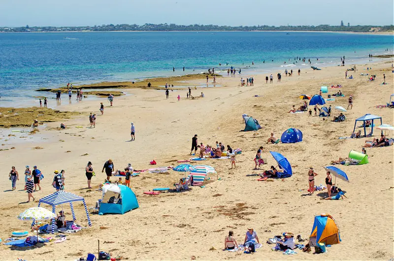 Queenscliff, VIC Queenscliff Beach Victoria. Crowds of tourists enjoying summer beach fun in the sun.  The seaside village of Queenscliff is located on the Bellarine Peninsula and has large stretches of coastline.